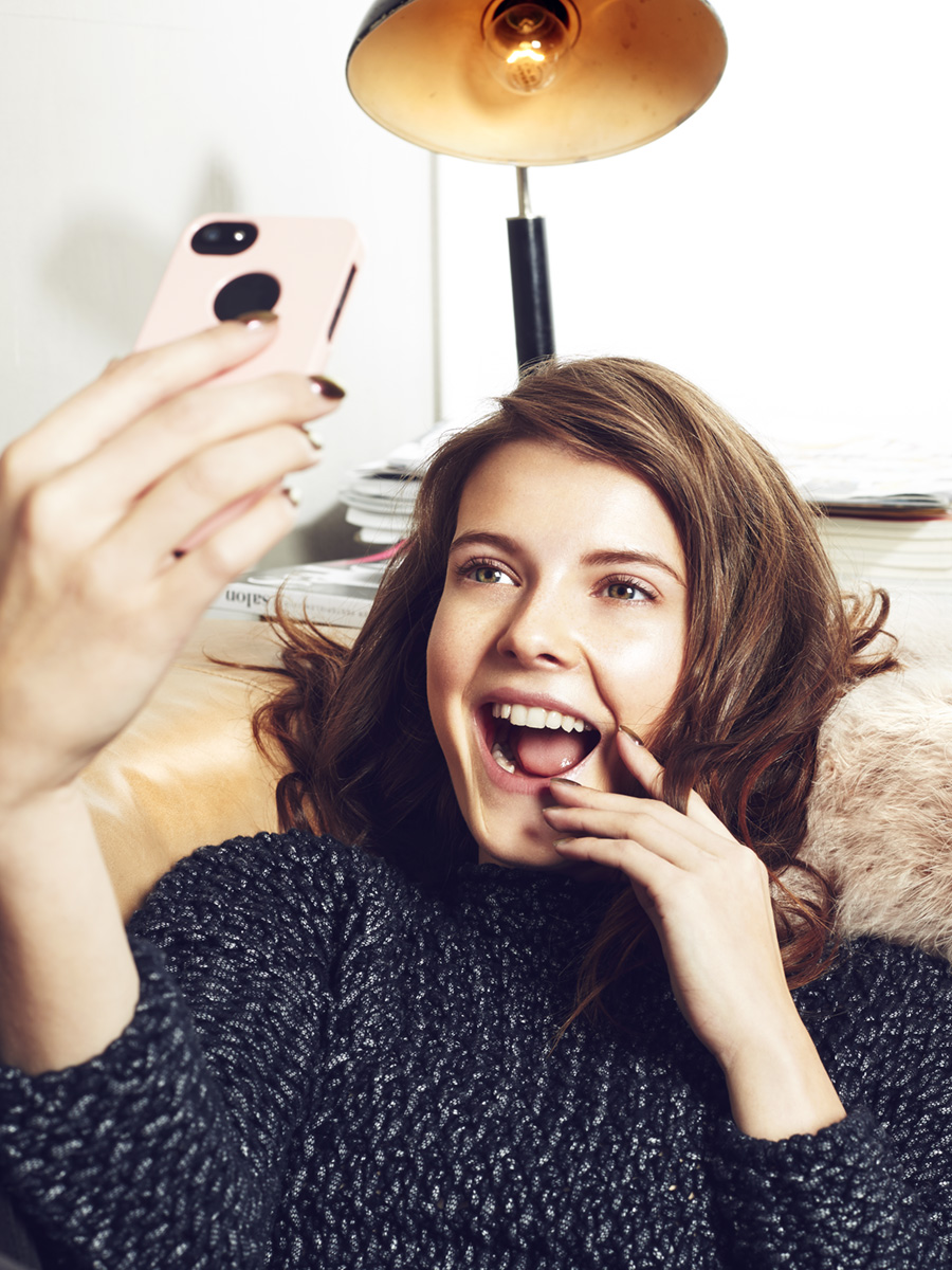 Brünettes Model lachendes Selfie auf der Couch